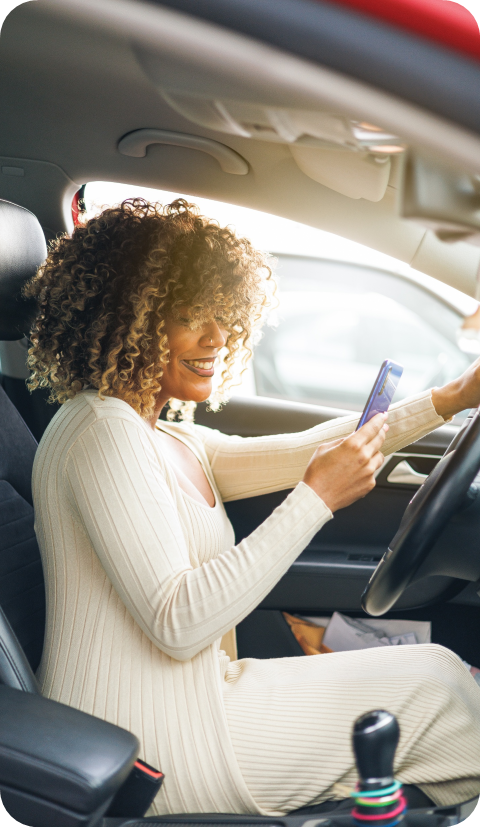 Jordan in her car looking at her phone